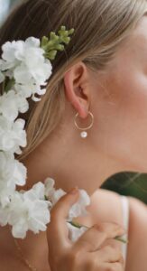 girl wearing pearl earrings in a blog post of 9 must have jewelry for everyday wear