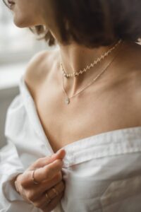 Girl wearing layered necklace in a blog post of 9 must have jewelry for everyday wear