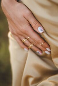 girl wearing golden finger rings in a blog post of 9 must have jewelry for everyday wear