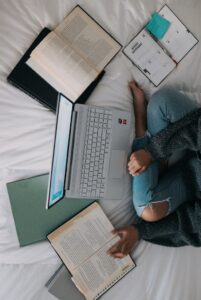 Girl with laptop and books in How to stay motivated to study blog