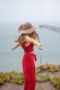 Woman wearing co-ord set in red colour with a brown hat in fashion and lifestyle blog by Ritu Biswas with the topic 11 summer fashion trends that are easy to follow