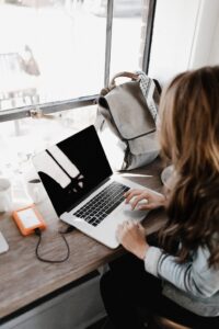 woman working on a laptop in the blog Why Self-Care Is Important And 6 Habits To Implement For A Healthy Lifestyle by Ritu Biswas