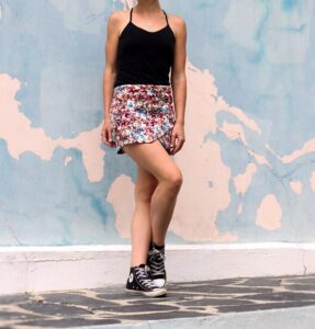 Woman wearing black spaghetti top and short printed skirt in "6 ways to style spaghetti tops" Woman wearing black spaghetti top and short printed skirt in "6 ways to style spaghetti tops"