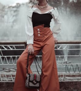 Woman wearing black spaghetti top over a button down shirt and brown palazzo pants in "6 ways to style spaghetti tops" Woman wearing black spaghetti top over a button down shirt and brown palazzo pants in "6 ways to style spaghetti tops"